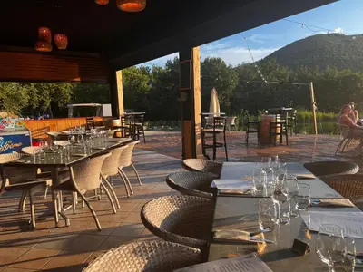 a restaurant with tables and chairs with a view of a mountain at Domaine de l'Espinet in Quillan