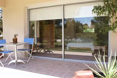 a patio with a table and chairs and a large window at Manor Norbert in Ventenac-Cabardès