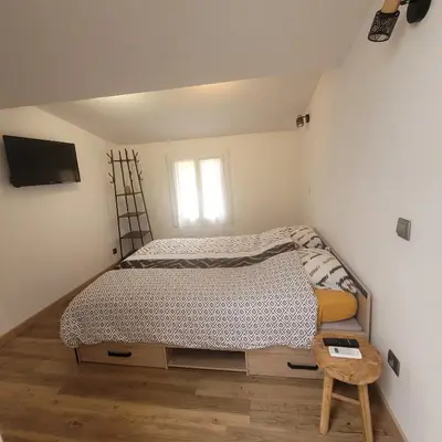 a small bedroom with a bed and a chair at Détente et plaisir à Taltahull in Tautavel
