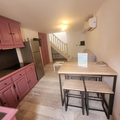 a kitchen with a small table and a kitchen with a staircase at Détente et plaisir à Taltahull in Tautavel