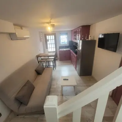 a living room with a couch and a kitchen at Détente et plaisir à Taltahull in Tautavel
