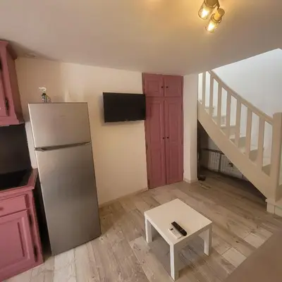 a kitchen with a refrigerator and a table and stairs at Détente et plaisir à Taltahull in Tautavel