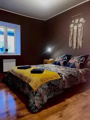 a bedroom with a bed with a yellow blanket on it at Appartement centre-ville in Carcassonne