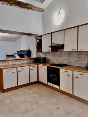a kitchen with white cabinets and a stove top oven at Appartement centre-ville in Carcassonne