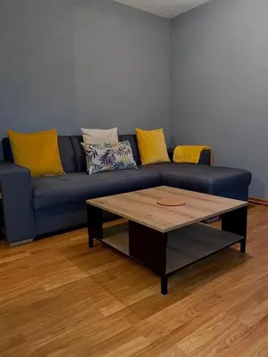 a blue couch with yellow pillows and a coffee table at Appartement centre-ville in Carcassonne