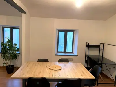a wooden table in a room with chairs and a window at Appartement centre-ville in Carcassonne