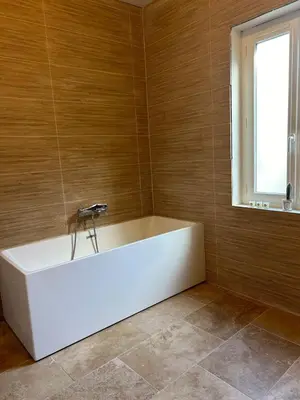 a white bath tub in a room with a window at Maison Hortense Carcassonne in Carcassonne