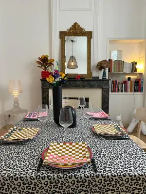 a table with plates and glasses and a mirror at Maison Hortense Carcassonne in Carcassonne
