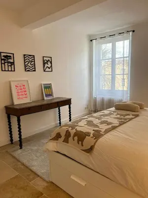 a bedroom with a large bed and a table at Maison Hortense Carcassonne in Carcassonne