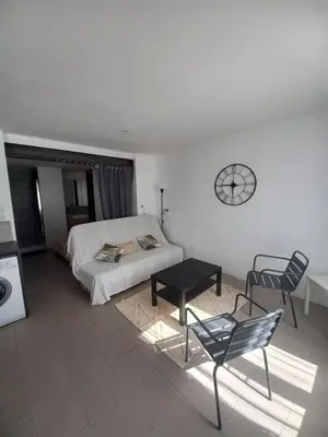 a bedroom with a bed and a table and a clock at Large studio near medieval city in Carcassonne