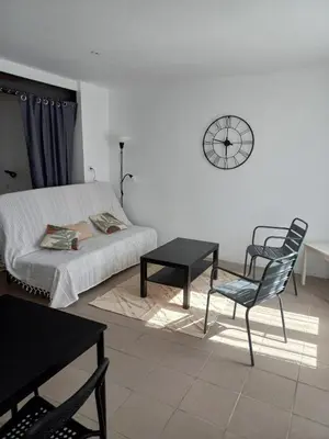 a bedroom with a bed and a chair and a clock at Large studio near medieval city in Carcassonne