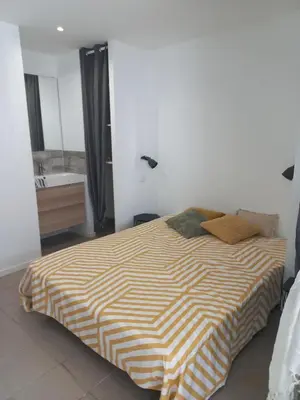a bedroom with a bed and a bathroom with a sink at Large studio near medieval city in Carcassonne