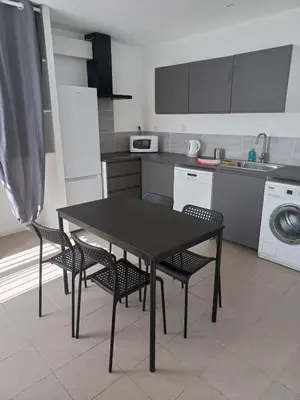 a kitchen with a table and chairs in a kitchen at Large studio near medieval city in Carcassonne
