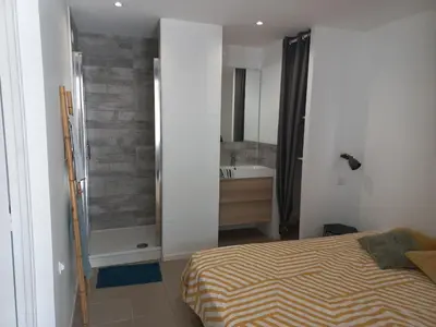 a bedroom with a bed and a bathroom with a sink at Large studio near medieval city in Carcassonne