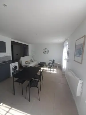 a room with two tables and chairs and a bed at Large studio near medieval city in Carcassonne