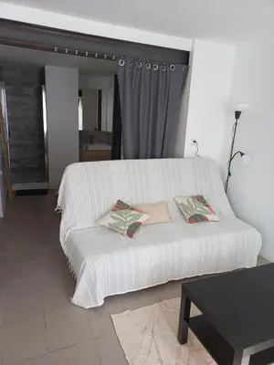 a white bed with two pillows on it in a room at Large studio near medieval city in Carcassonne
