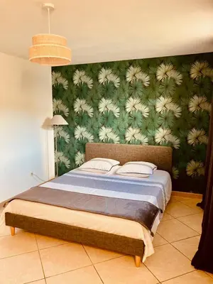 a bedroom with a bed with a green wall at Gite belle vue in Olargues
