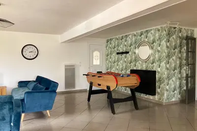 a living room with a table and a couch and a clock at Gite belle vue in Olargues