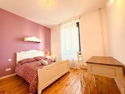 a bedroom with a white bed and a desk and a window at À 1min d'une base nautique Maison spacieuse avec piscine in Puicheric