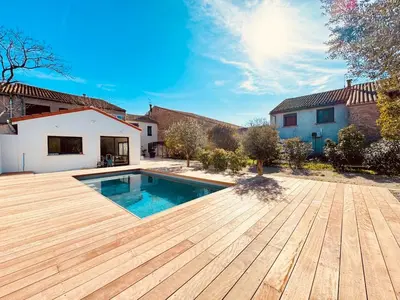 a backyard with a swimming pool and a wooden deck at À 1min d'une base nautique Maison spacieuse avec piscine in Puicheric