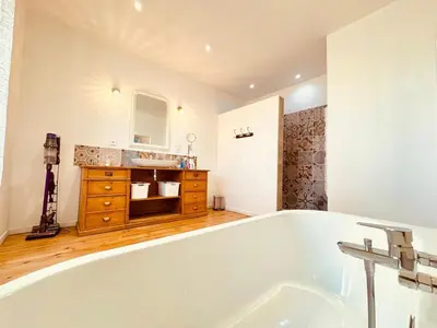 a large bath tub in a bathroom with a sink at À 1min d'une base nautique Maison spacieuse avec piscine in Puicheric