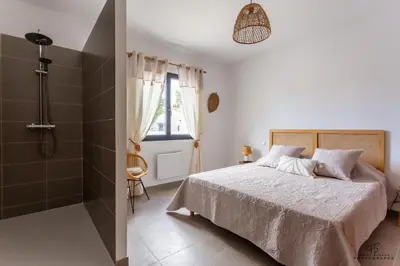 a bedroom with a bed and a shower at Clos de la Pounso in Lapalme