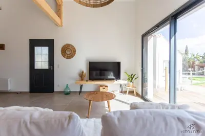 a living room with white walls and a large window at Clos de la Pounso in Lapalme