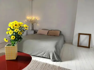 a bedroom with a bed and a vase of yellow flowers at Les Grands Cyprès - chambres d'hôtes in Conques-sur-Orbiel