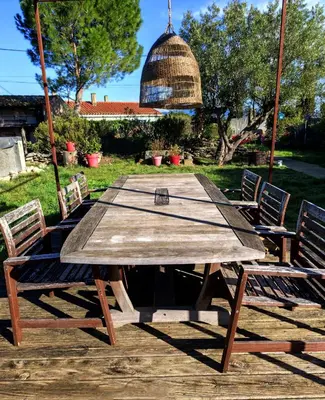 a wooden picnic table with two chairs around it at Les Grands Cyprès - chambres d'hôtes in Conques-sur-Orbiel