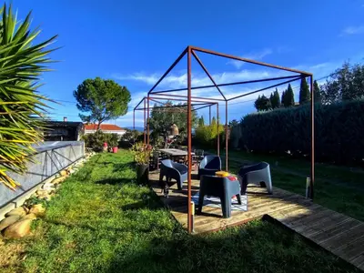a gazebo with chairs and a table in a yard at Les Grands Cyprès - chambres d'hôtes in Conques-sur-Orbiel