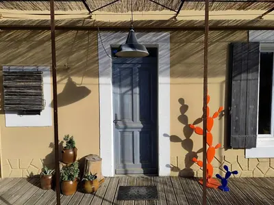 a house with a blue door and some potted plants at Les Grands Cyprès - chambres d'hôtes in Conques-sur-Orbiel