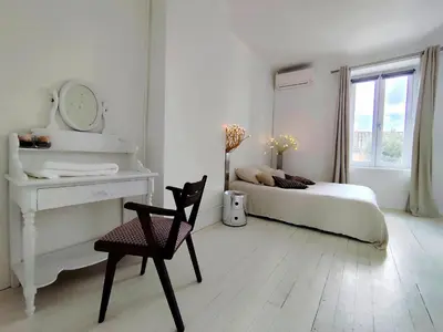 a bedroom with a bed and a mirror and a desk at Les Grands Cyprès - chambres d'hôtes in Conques-sur-Orbiel