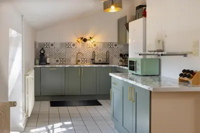 a kitchen with blue cabinets and a tile floor at Loft Sénéchal - Rare Elegance in Carcassonne
