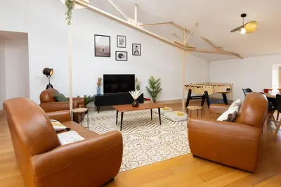 a living room with leather furniture and a fireplace at Loft Sénéchal - Rare Elegance in Carcassonne