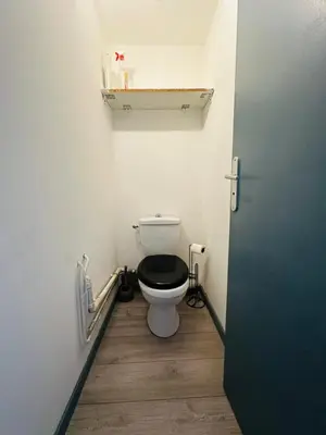 a bathroom with a toilet with a black seat at Appartement T3 proche centre-ville NARBONNE in Narbonne