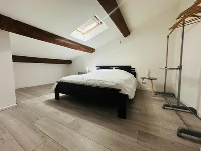 a bedroom with a bed and a wooden floor at Appartement T3 proche centre-ville NARBONNE in Narbonne