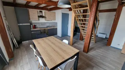 a kitchen with a wooden table and white chairs at Appartement T3 proche centre-ville NARBONNE in Narbonne