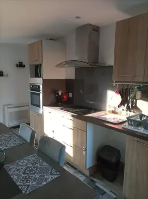 a kitchen with wooden cabinets and a counter top at Chez Sabine la Campagne HAUT in Narbonne