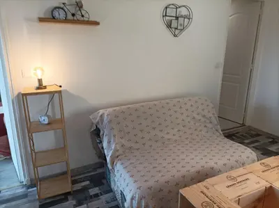a bedroom with a bed and a wooden shelf at Chez Sabine la Campagne HAUT in Narbonne