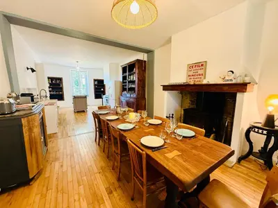 a dining room with a long table and a fireplace at Domaine Riplou - Maison de Campagne avec piscine in Verdun-en-Lauragais