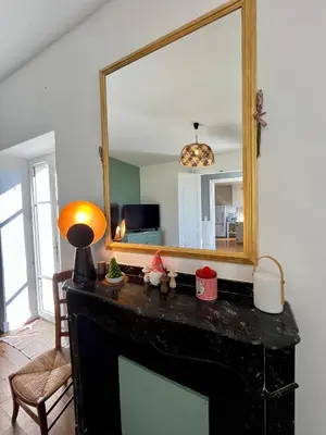 a living room with a fireplace and a mirror at Domaine Riplou - Maison de Campagne avec piscine in Verdun-en-Lauragais