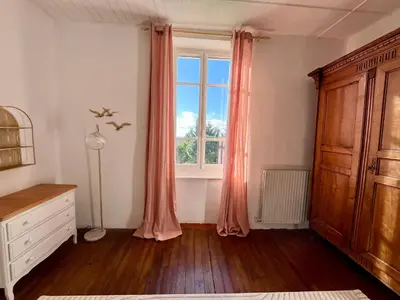 a bedroom with a window with pink curtains and a dresser at Domaine Riplou - Maison de Campagne avec piscine in Verdun-en-Lauragais