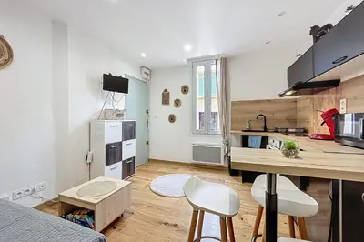 a kitchen with a table and chairs in a room at Charming studio near the city center of Narbonne in Narbonne