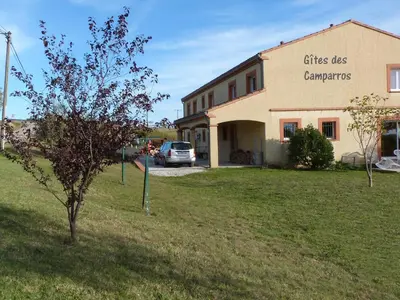 a building with a tree in front of a building at Gites des Camparros in Nailloux