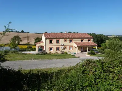 a large white house with a driveway at Gites des Camparros in Nailloux