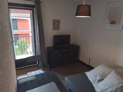a bedroom with a bed and a tv and a window at Mas Dels Caminhs in Villepinte