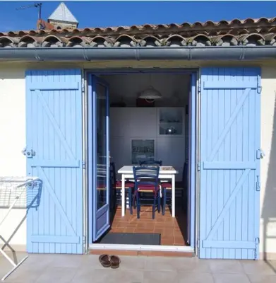 an open door to a patio with a table at La maison du soleil in Villar-Saint-Anselme