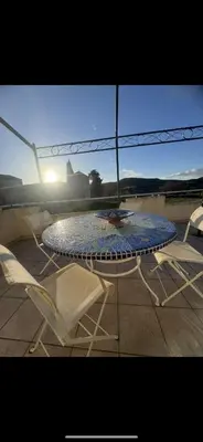 a glass table and chairs on a patio at La maison du soleil in Villar-Saint-Anselme