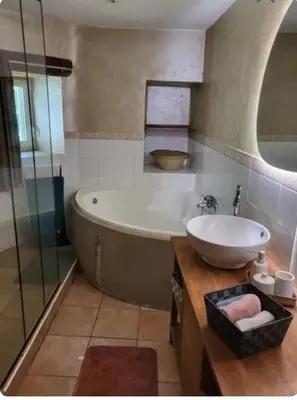 a bathroom with a tub and a sink at La Maison du chataignier in Cassagnolles