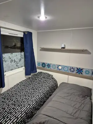 a small bedroom with a bed and a window at Mobil-home Climatisé 6 personnes à Port La Nouvelle in Port-la-Nouvelle